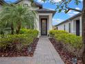 Welcoming front entry with brick walkway and lush landscaping at 2597 Mariotta Rdg, Clermont, FL 34715