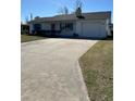 Front view of a single-story home with a long driveway and grassy yard at 2620 Janet St, Kissimmee, FL 34741