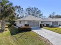 Exterior view of a house with a screened-in garage and landscaping at 26912 Tanner St, Leesburg, FL 34748