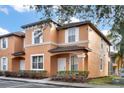 Front view of a two-story townhome with orange exterior and landscaping at 2713 Impala Ln, Kissimmee, FL 34746