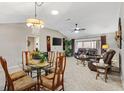 Open dining area with glass table and leather living room furniture at 2954 Silk Tree Ter, The Villages, FL 32163