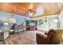 Living room features wood ceiling, comfy recliner, and built-in shelving at 32125 Mark Ave, Tavares, FL 32778