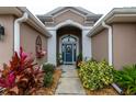 Front entry with a blue door, and nicely landscaped walkway at 3257 Triton Ct, The Villages, FL 32163