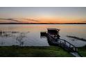 Lakefront property with a wooden dock and sunset view at 33648 Picciola Dr, Fruitland Park, FL 34731