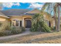 Inviting home exterior featuring a welcoming front porch and walkway with beautiful landscaping at 35808 Rose Moss Ave, Leesburg, FL 34788