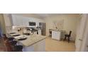 Well-lit kitchen features granite countertops, modern appliances, and an eat-in dining area at 3621 Amelia Ave, The Villages, FL 32162