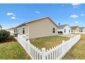 Side view of beige house with white picket fence at 5415 Kate Ct, The Villages, FL 32163