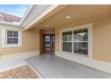 View of the covered front porch showcasing the front door, decorative window and front patio at 583 Arruda Ter, The Villages, FL 32162
