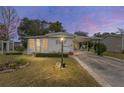 Mobile home at dusk with a landscaped yard and driveway at 807 Maple Ln, The Villages, FL 32159