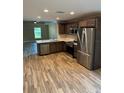 Modern kitchen featuring dark brown cabinets, stainless steel appliances, and a large island at 827 E Clifford Ave, Eustis, FL 32726