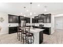 Modern kitchen with dark cabinets, stainless steel appliances, and a large island at 848 Carmillion Ct, Groveland, FL 34736