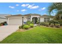 Well-maintained house featuring a lush lawn and a paved driveway at 848 Folsum Pl, The Villages, FL 32162