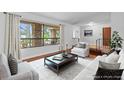 Virtually staged living room with hardwood floors and large windows at 9605 Hollyglen Pl, Windermere, FL 34786