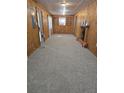 Spacious living room showcasing wood paneling, a fireplace, and neutral colored carpeting at 10094 Sw 153Rd Ln, Dunnellon, FL 34432