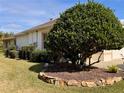 Exterior view of the house with a large bush and stone landscaping at 1515 Gadsden Pl, The Villages, FL 32162