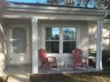 Inviting front porch with two red adirondack chairs and a small table at 24825 Pine Hl, Leesburg, FL 34748