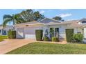 Charming one-story house with a white exterior, attached garage, and neat landscaping at 26607 Racquet Cir, Leesburg, FL 34748