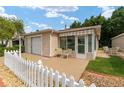 Tan house with white picket fence, single car garage, and nicely landscaped lawn at 317 Emmalee Pl, The Villages, FL 32162