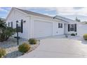 White house with two-car garage and landscaped front yard at 446 Flossmoor Ct, The Villages, FL 32162