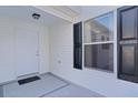 White front door with black shutters and a welcome mat at 446 Flossmoor Ct, The Villages, FL 32162
