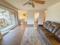 Living room with brown recliner sofa and view into dining area at 723 Perkins St # 203, Leesburg, FL 34748