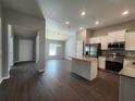 Open-concept kitchen featuring stainless steel appliances, granite countertops and wood flooring at 8101 Sw 128Th Loop, Ocala, FL 34473