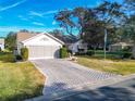 House exterior showcasing a paved driveway and lush lawn at 901 Pasadena Way, Lady Lake, FL 32159