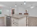 Kitchen island with wine cooler and granite countertop at 10406 Lakeshore Dr, Clermont, FL 34711