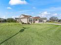 Tan house with brown roof, landscaping, and a two-car garage at 17880 Se 86Th Oak Leaf Ter, The Villages, FL 32162