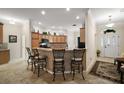Open kitchen with counter seating, tile backsplash, and ample cabinet space at 2709 Astoria Ave, The Villages, FL 32162