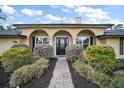 Charming single-story home with a stone walkway, manicured bushes, and a stylish front door at 29319 Old Mill E, Tavares, FL 32778