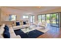 Open living area featuring hardwood floors, white sofas, and access to a patio with views of the garden at 4668 Tower Pine Rd # Ge, Orlando, FL 32839