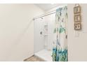 Shower stall with a white tile surround and floral shower curtain at 4861 Panga Ave, Mount Dora, FL 32757