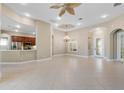 Open living room with tile floors, kitchen island, and access to a lanai at 6027 Spinnaker Loop, Lady Lake, FL 32159