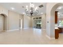 Bright living room with tile floors, chandelier, and sliding doors to patio at 6027 Spinnaker Loop, Lady Lake, FL 32159