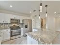 Modern kitchen featuring stainless steel appliances, granite countertops, and stylish pendant lighting at 8338 Se 178Th Deveaux Ln, The Villages, FL 32162