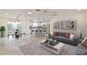 Bright, open-concept living room with modern furniture and decor, flowing into the kitchen and dining area at 8338 Se 178Th Deveaux Ln, The Villages, FL 32162