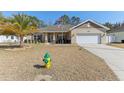 House with palm trees, driveway and American flag at 10291 Se 69Th Ter, Belleview, FL 34420