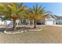 House exterior showcasing landscaping with palm trees at 10291 Se 69Th Ter, Belleview, FL 34420