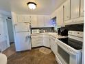 Well-lit kitchen featuring white cabinets, modern appliances, and ample countertop space at 114 Chestnut St, Leesburg, FL 34748
