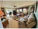 Inviting living room with a plush sofa, recliner, ceiling fan, and decorative rug on wood-look floors at 114 Chestnut St, Leesburg, FL 34748