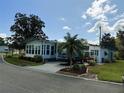 Single-wide manufactured home with palm tree and driveway at 123 Pyracantha Ln, Leesburg, FL 34748