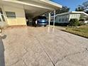 Long stamped concrete driveway leading to a covered carport at 169 Bougainvillea Dr, Leesburg, FL 34748