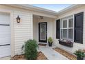 Inviting front entrance featuring a decorative door, black shutters, and flower accents at 17760 Se 91St Gaylark Ave, The Villages, FL 32162