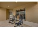 Inviting covered front porch with two rocking chairs and a small accent table by the front door at 1941 Loadstar Ave, The Villages, FL 32162