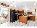 Galley kitchen with island, stainless steel appliances, and wood cabinets at 2043 Sawgrass Dr, Apopka, FL 32712