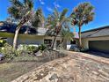 House exterior showcasing a ranch style home with palm trees and a driveway at 208 First St, Tavares, FL 32778