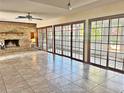 Bright Gathering room featuring tile floors, a brick fireplace, and sliding glass doors at 208 First St, Tavares, FL 32778