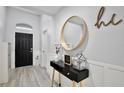 Bright entryway with a black door, console table, and large round mirror at 2320 Blue Meadows Ct, Apopka, FL 32703