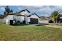 Modern, single-story home with a dark gray garage door and lush lawn at 2320 Blue Meadows Ct, Apopka, FL 32703